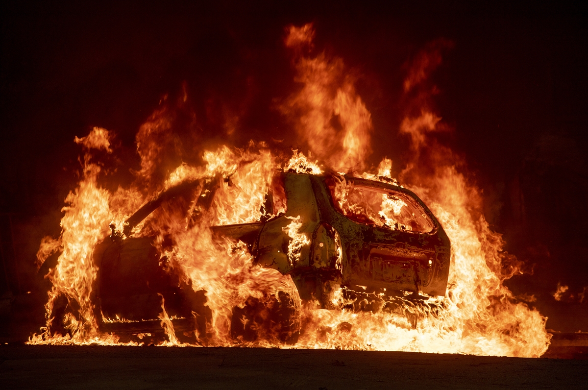 A car explodes into flames as the Camp fire tears through downtown Paradise, California on November 8, 2018.