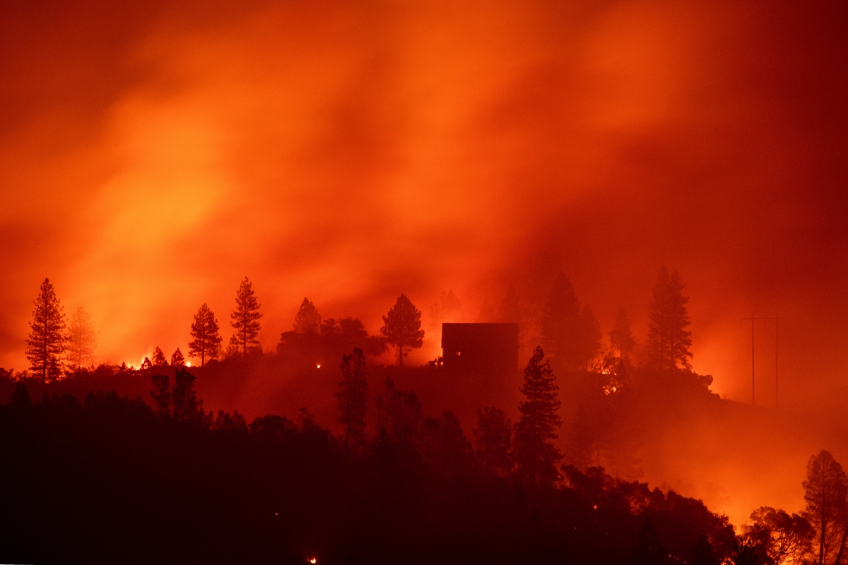 Flames from the Camp fire burn near a home atop a ridge near Big Bend, California, on November 10, 2018.