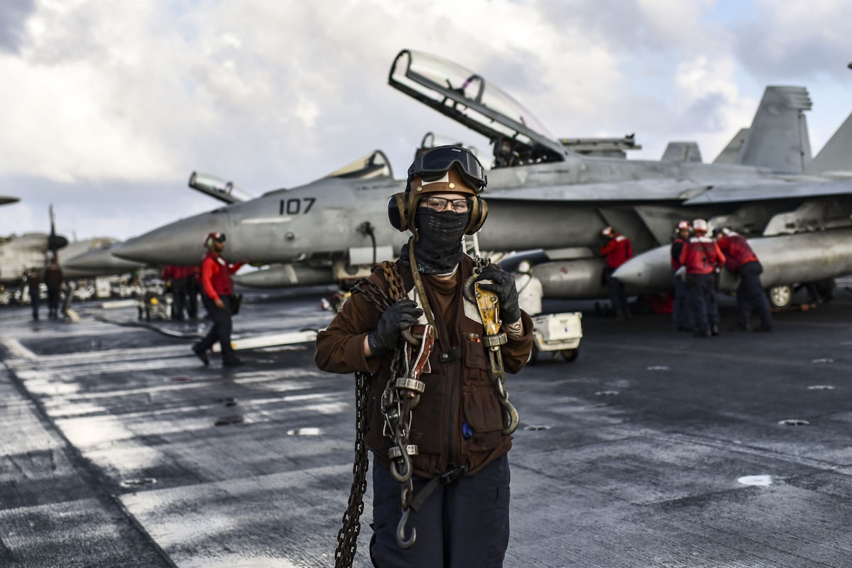 Crew members of US aircraft carrier USS Harry S Truman work on the flight deck of the ship in the eastern Mediterranean Sea on May 8, 2018.