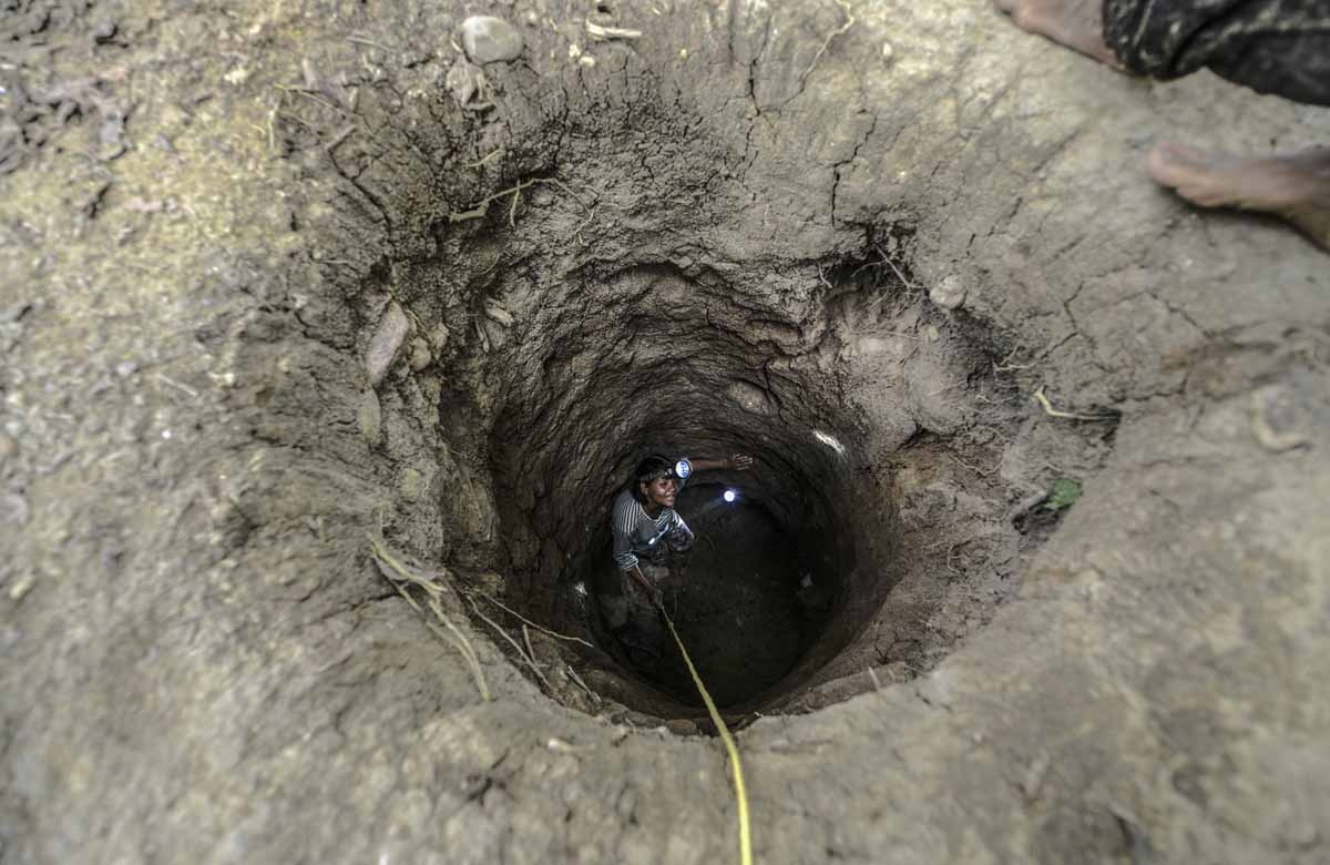 A worker descends into an underground gold mine on the bank of a river in El Callao, Bolivar state, southeastern Venezuela on February 24, 2017. Although life in the mines of eastern Venezuela is hard and dangerous, tens of thousands from all over the cou