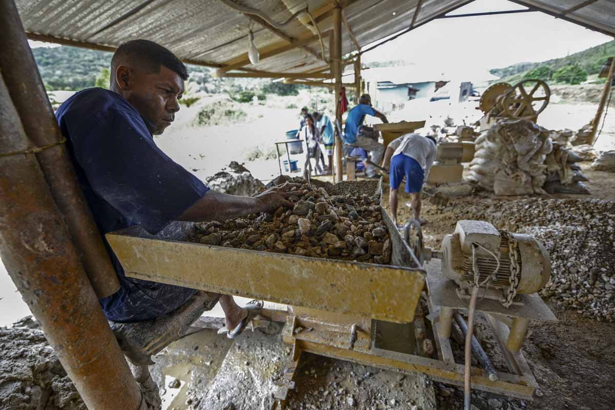 A man works at a stone crusher machine in a gold mine in El Callao, Bolivar state, southeastern Venezuela on February 25, 2017. Although life in the mines of eastern Venezuela is hard and dangerous, tens of thousands from all over the country head for the
