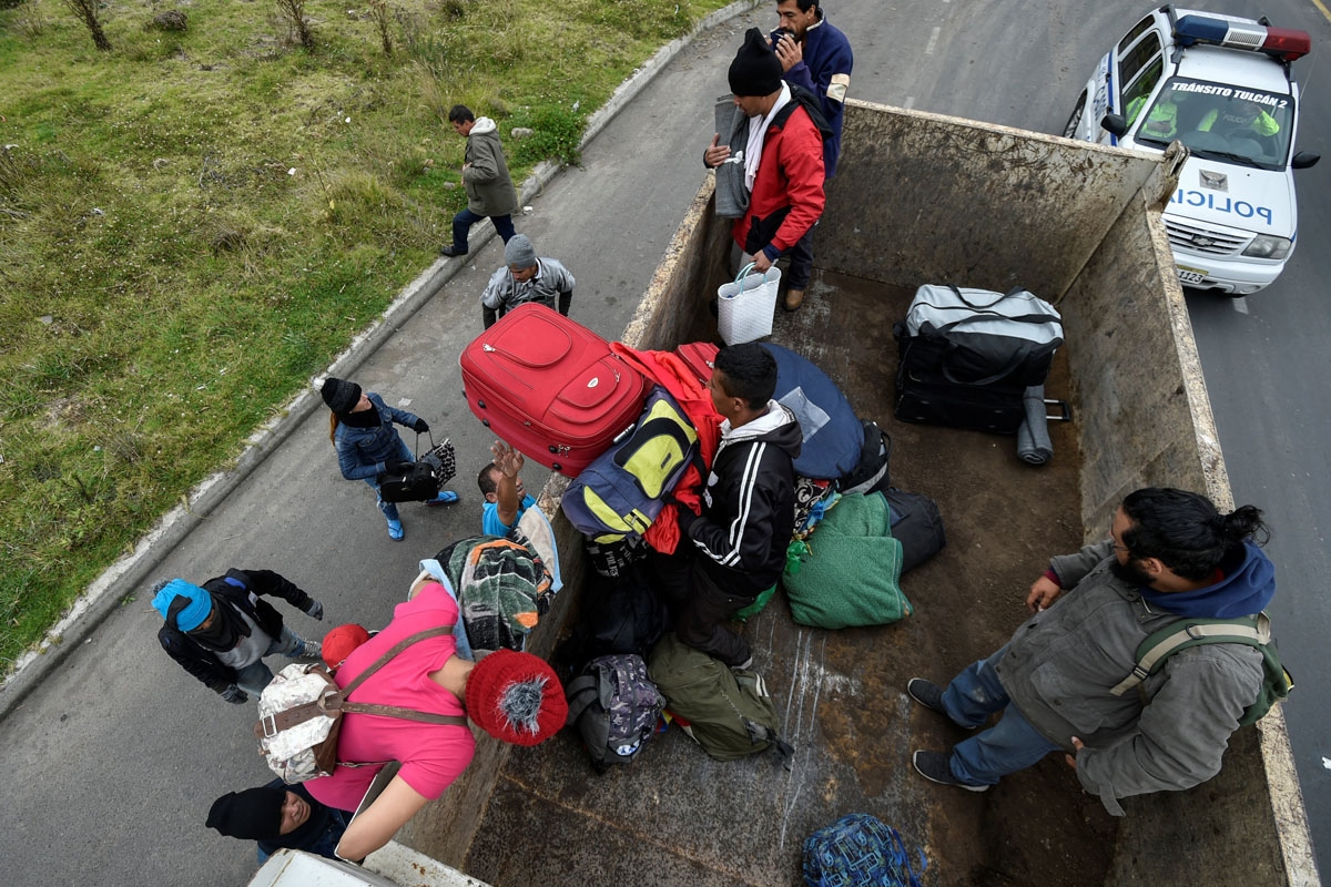 Venezuelan migrants get on a truck on their way to Peru at the Panamerican highway in Tulcan, Ecuador, after crossing from Colombia, on August 21, 2018.
