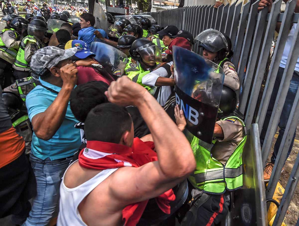 Venezuela's opposition activists clash with riot police agents during a protest against Nicolas Maduro's government in Caracas on April 4, 2017. Protesters clashed with police in Venezuela Tuesday as the opposition mobilized against moves to tighten Presi