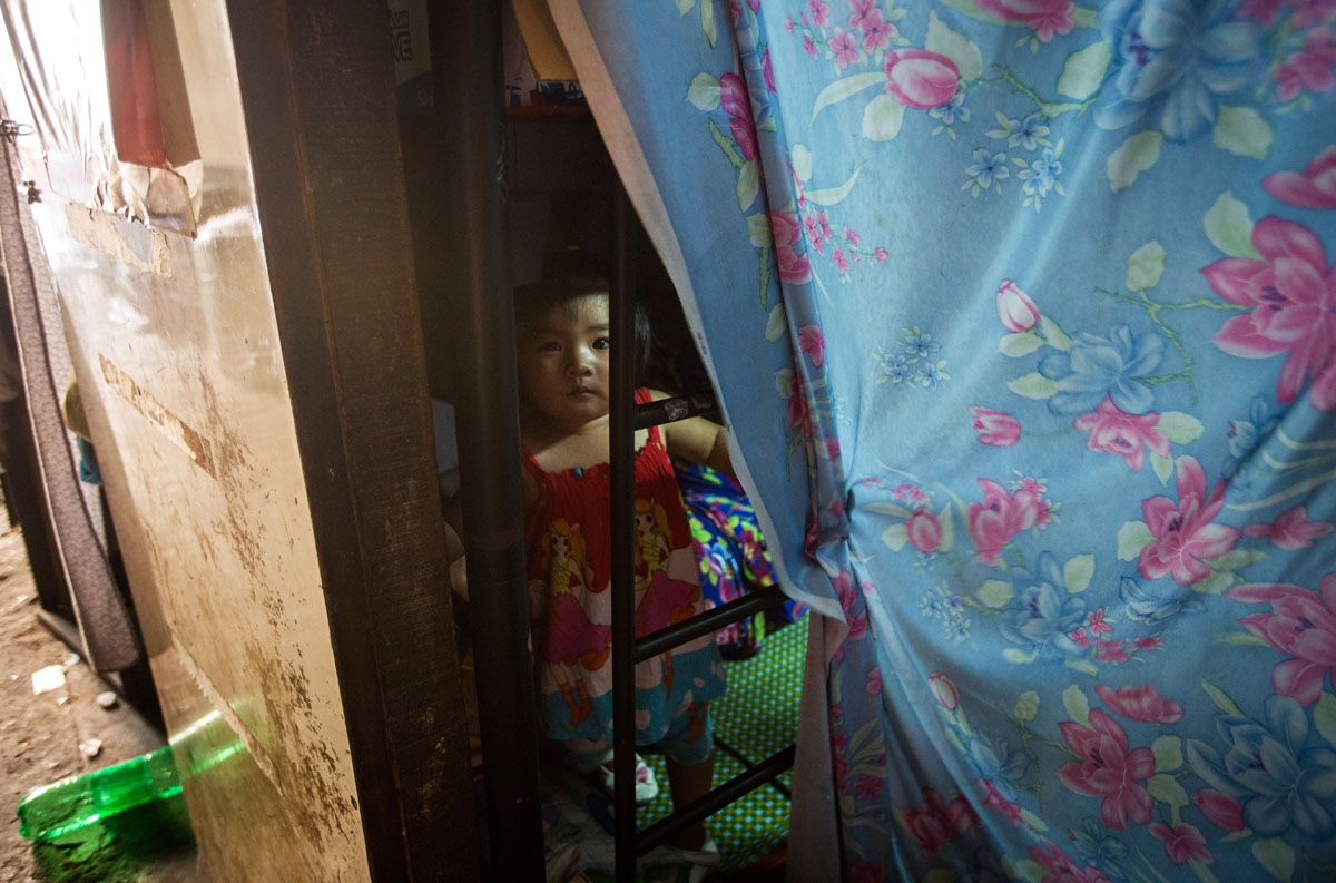A girl looks out from her uncle's two-square-metre home in Ho Chi Minh City on May 2, 2018.