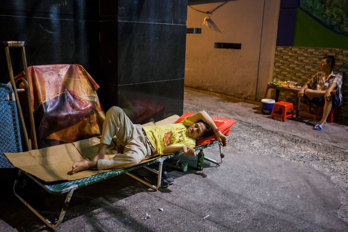 Pham Quoc Cong rests on a makeshift bed outside his two-square-metre home in Ho Chi Minh City on May 2, 2018.
