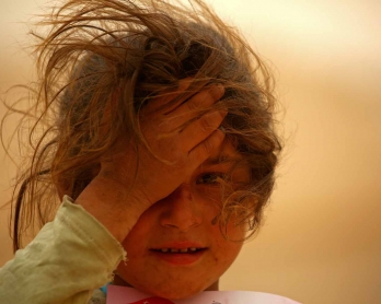 A displaced Syrian girls looks on at the al-Mabrouka camp in the village of Ras al-Ain on the Syria-Turkey border, where many Syrians who fled from territory held by the Islamic State (IS) group in Deir Ezzor and Raqa are taking shelter on April 23, 2017.