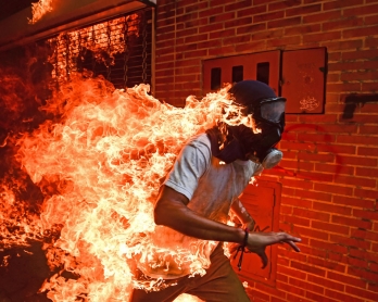A demonstrator catches fire during clashes with riot police within a protest against Venezuelan President Nicolas Maduro, in Caracas on May 3, 2017. 
