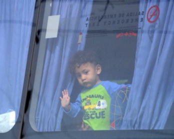 Un niño inmigrante que viajaba solo es transportado a San Pedro Sula, 240 Km al norte de Tegucigalpa, el 2 de julio de 2014, tras ser deportado de Estados Unidos (AFP / Orlando Sierra)